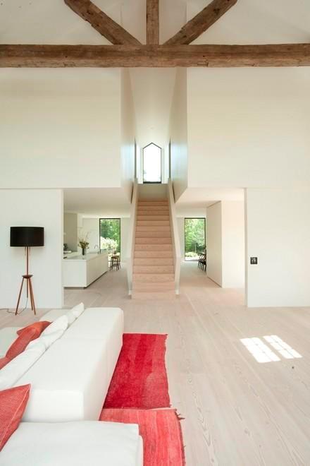 living area with plenty of natural light, a high ceiling, beamed ceiling, and stairs