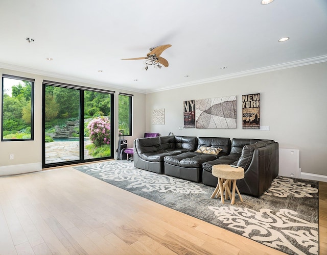 living area with ceiling fan, wood finished floors, baseboards, and ornamental molding