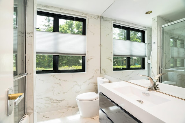 full bathroom with plenty of natural light, a marble finish shower, marble finish floor, and toilet