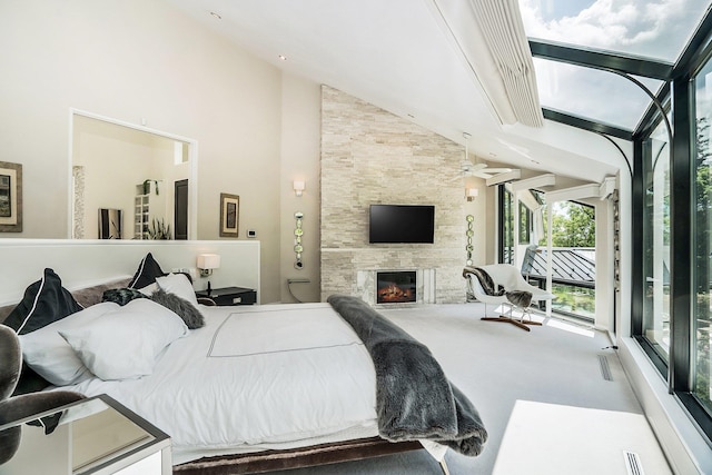 carpeted bedroom with access to outside, a fireplace, and high vaulted ceiling