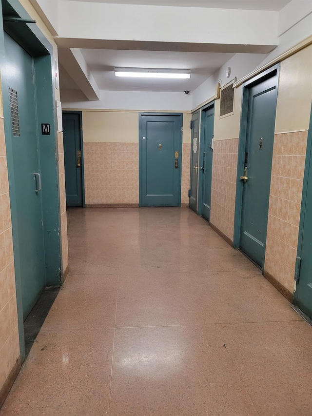 1503 Metropolitan Ave Unit 2F, Bronx, NY 10462 - corridor with wainscoting, tile walls, and speckled floor