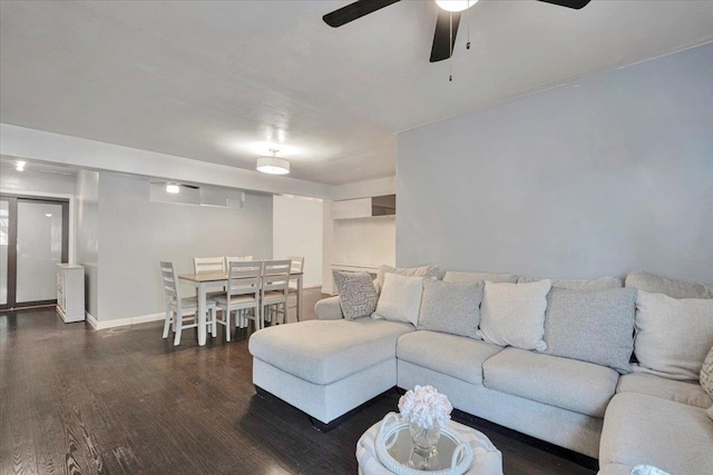 living area featuring baseboards, ceiling fan, and wood finished floors