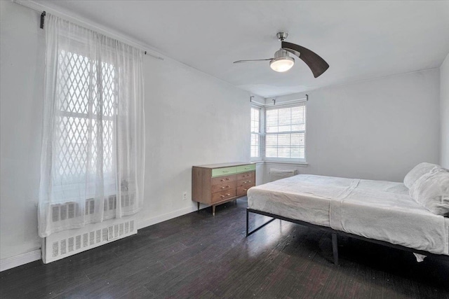 bedroom featuring baseboards, ceiling fan, wood finished floors, and visible vents