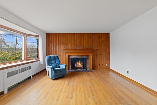 12 Brundage St, Armonk, NY 10504 - unfurnished room with a brick fireplace, wood walls, wood finished floors, baseboards, and radiator