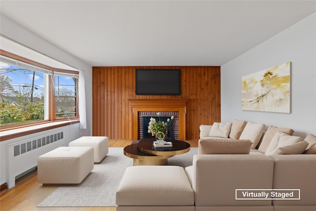 12 Brundage St, Armonk, NY 10504 - living area with wood walls, radiator, a brick fireplace, and an accent wall
