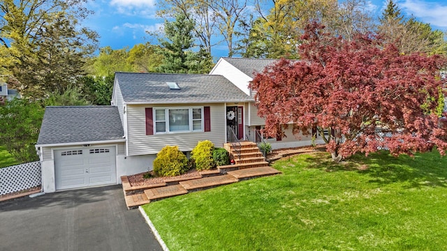 view of front of house with aphalt driveway, a shingled roof, a front yard, and a garage