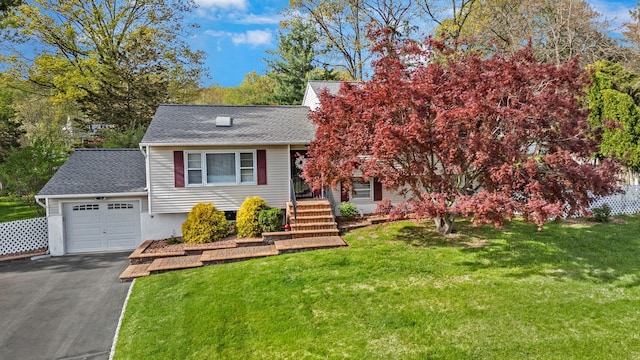 view of front of property with a garage, a front lawn, roof with shingles, and aphalt driveway