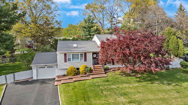 view of front of house with a front yard, an attached garage, roof with shingles, and aphalt driveway