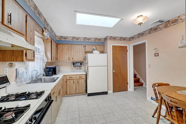 kitchen with a sink, white appliances, light countertops, a skylight, and visible vents