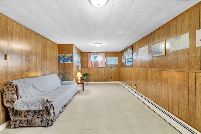 living area featuring a baseboard heating unit and wood walls