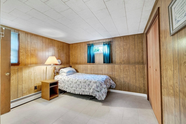 tiled bedroom featuring wooden walls and baseboard heating