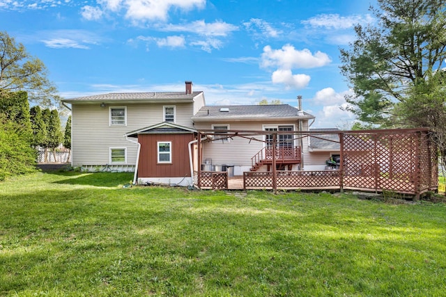 rear view of property featuring a storage unit, a deck, a chimney, a lawn, and an outdoor structure