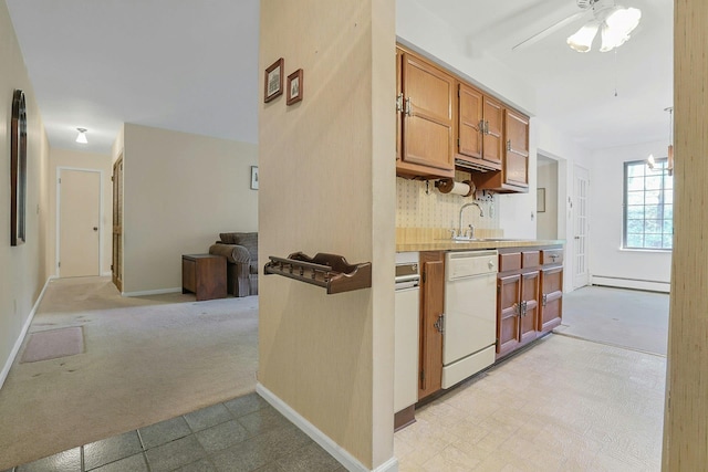kitchen with brown cabinets, decorative backsplash, a baseboard radiator, light colored carpet, and white dishwasher
