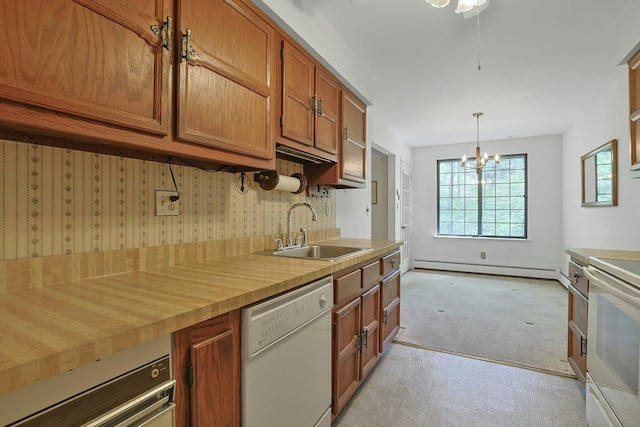 kitchen with brown cabinets, a sink, light countertops, a baseboard heating unit, and white appliances