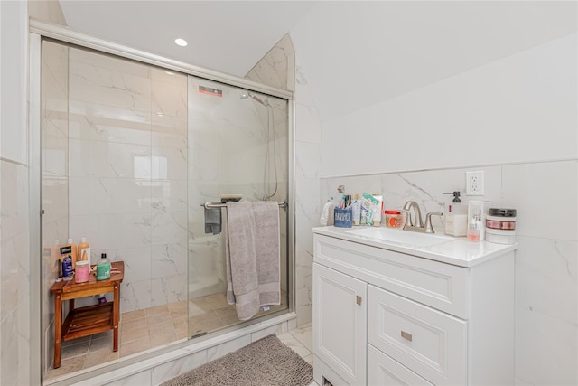full bath with tile walls, vanity, recessed lighting, and a marble finish shower