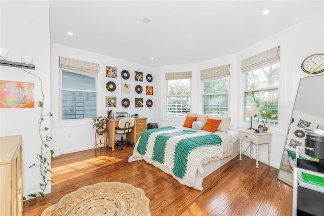 bedroom with recessed lighting, multiple windows, and wood finished floors