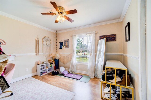 office area featuring ceiling fan, baseboards, crown molding, and wood finished floors