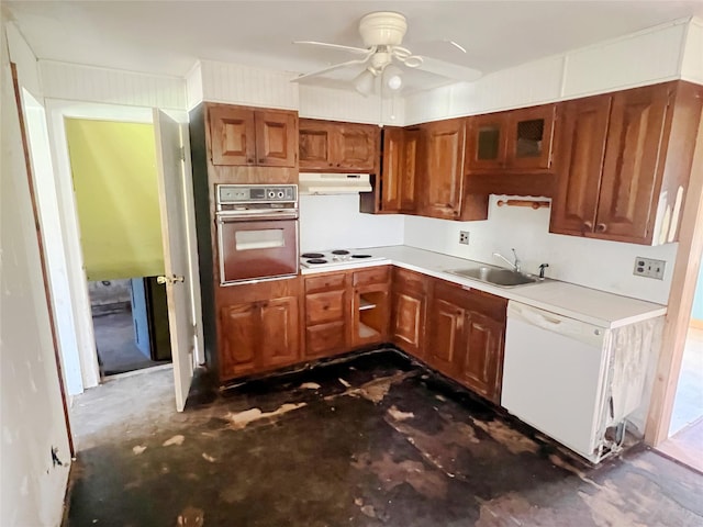 kitchen featuring a sink, under cabinet range hood, white appliances, a ceiling fan, and brown cabinetry