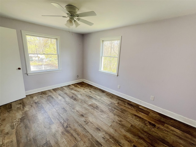 unfurnished room with ceiling fan, wood finished floors, and baseboards