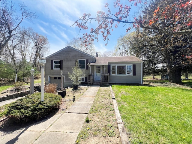 tri-level home with a front yard, driveway, and a garage