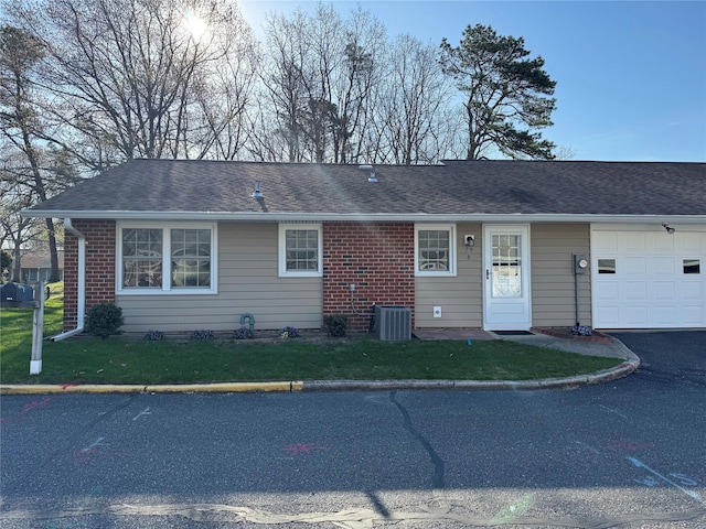 79 Enfield Ct Unit B, Ridge, NY 11961 - single story home with a shingled roof, driveway, a front yard, and a garage