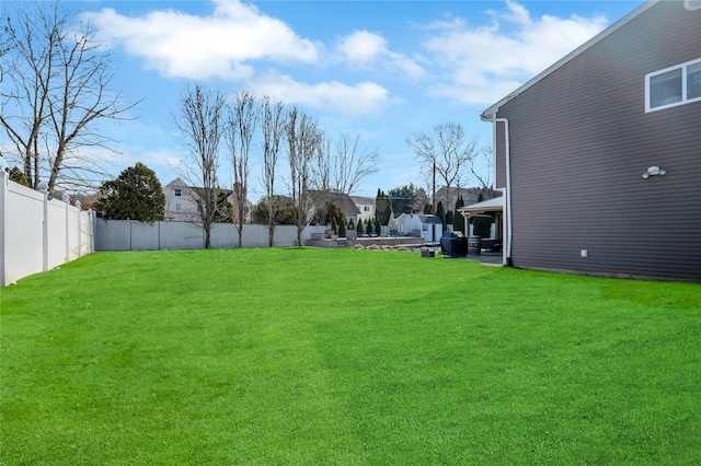 view of yard with a patio, fence, and a residential view