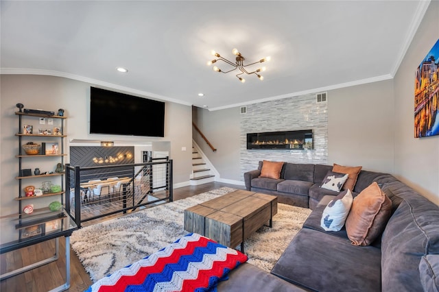 living room with ornamental molding, visible vents, a large fireplace, and wood finished floors