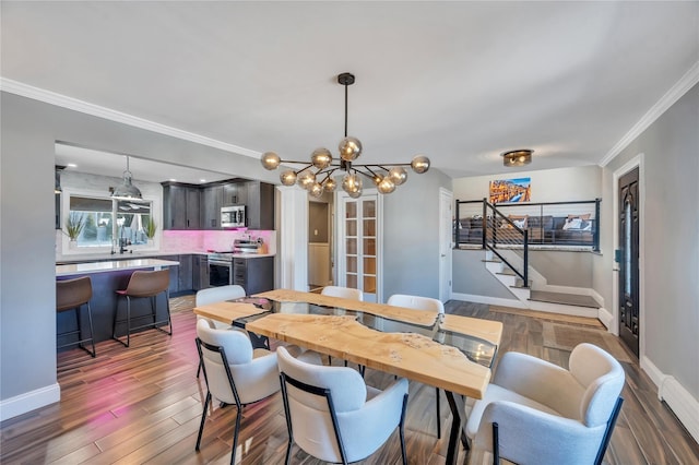dining room with stairway, baseboards, crown molding, and a chandelier