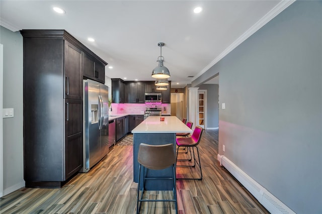 kitchen featuring recessed lighting, light countertops, appliances with stainless steel finishes, and a baseboard heating unit