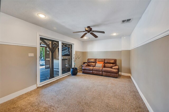 living area with a ceiling fan, baseboards, visible vents, and carpet