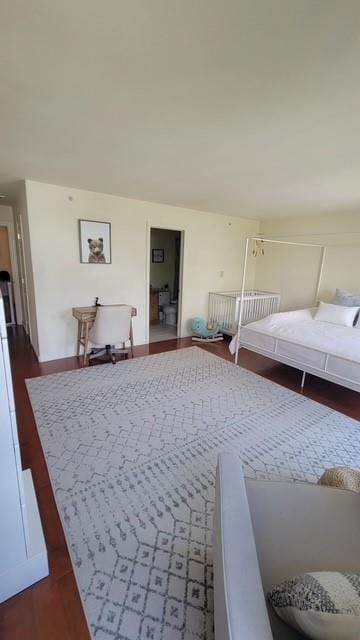 bedroom featuring baseboards and dark wood-type flooring