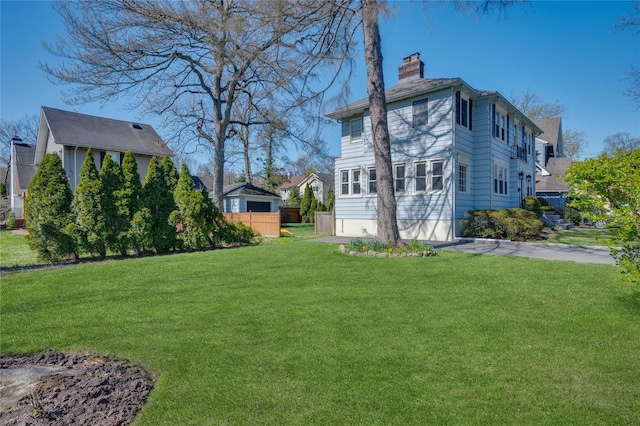 rear view of house with a chimney and a yard