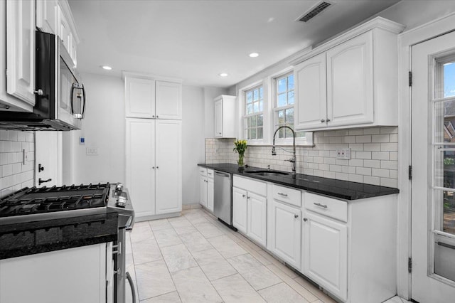 kitchen with visible vents, a sink, white cabinetry, and stainless steel appliances