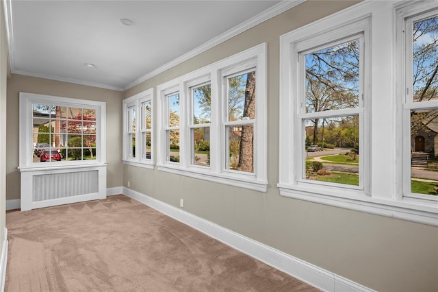 unfurnished sunroom featuring baseboards, radiator heating unit, and a wealth of natural light