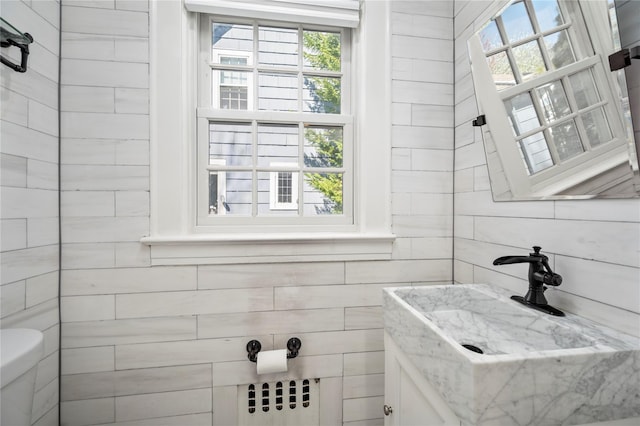bathroom featuring vanity, radiator heating unit, and toilet