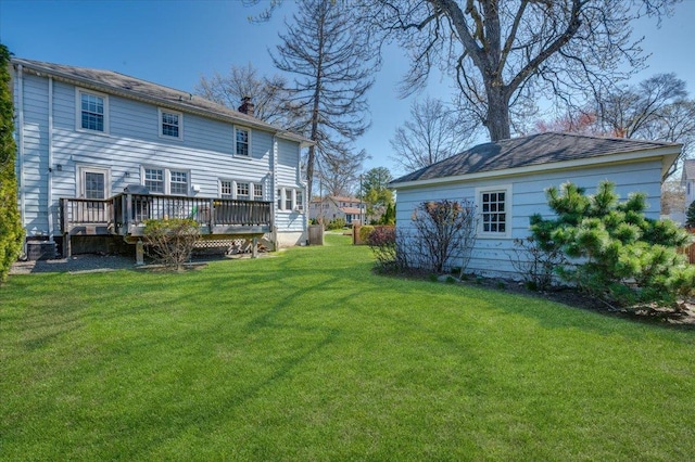 back of property featuring a chimney, central AC unit, a lawn, and a deck