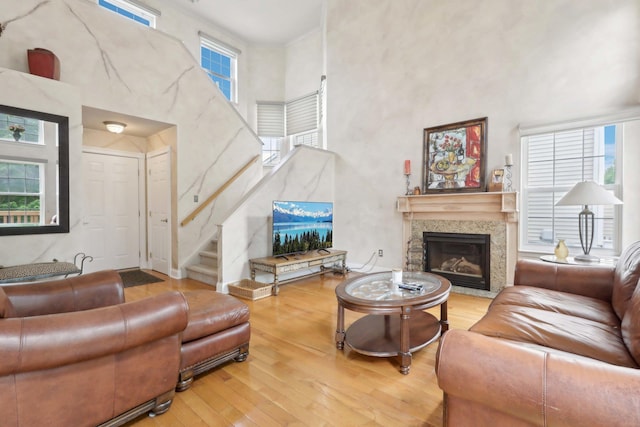 36 Alexander Dr, Washingtonville, NY 10992 - living room with a towering ceiling, hardwood / wood-style flooring, healthy amount of natural light, a glass covered fireplace, and stairs