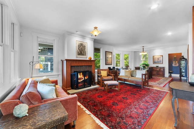 living room with light wood-style flooring, a fireplace with flush hearth, and recessed lighting