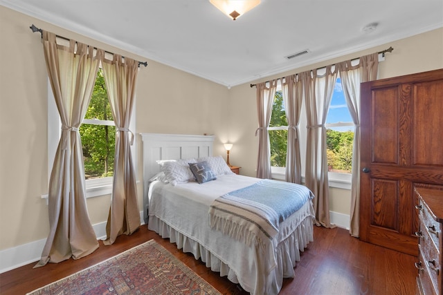 bedroom featuring wood finished floors, baseboards, and ornamental molding