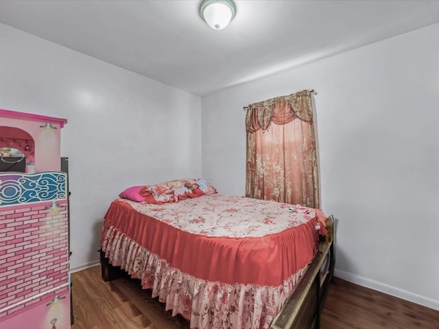 bedroom with wood finished floors and baseboards