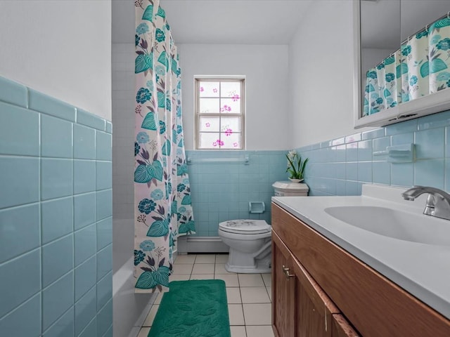 bathroom with tile patterned floors, toilet, tile walls, wainscoting, and vanity