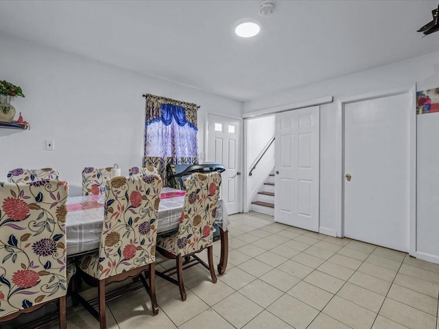 dining area featuring stairs and light tile patterned floors