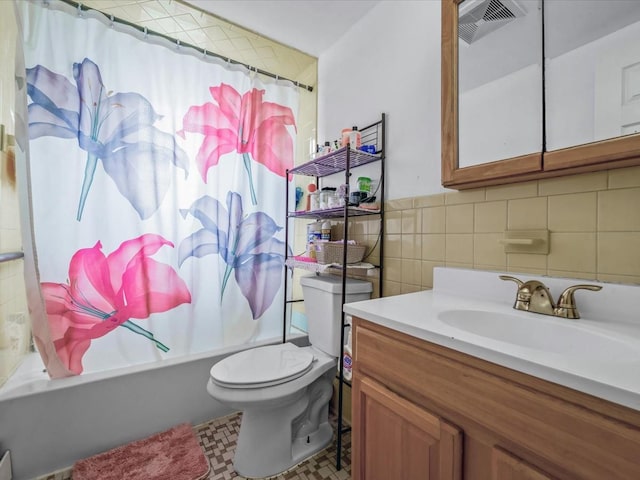 bathroom featuring visible vents, toilet, vanity, tile walls, and shower / tub combo