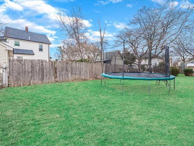 view of yard featuring fence and a trampoline