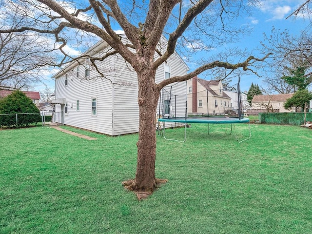 view of yard featuring fence and a trampoline