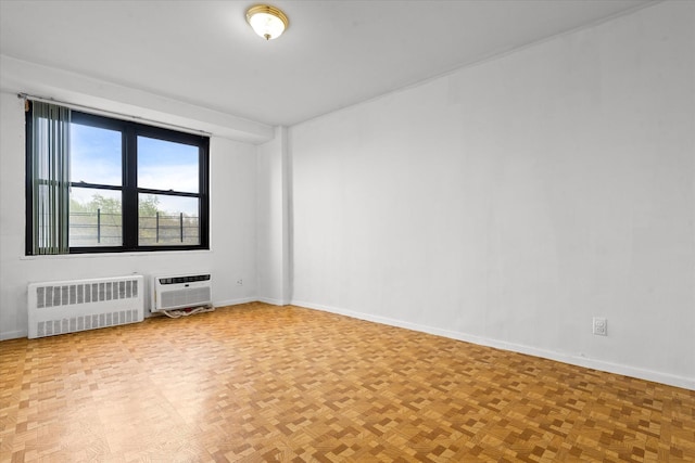 empty room featuring radiator and baseboards