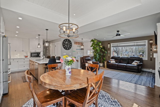 dining area with recessed lighting, a baseboard radiator, ceiling fan with notable chandelier, and hardwood / wood-style flooring