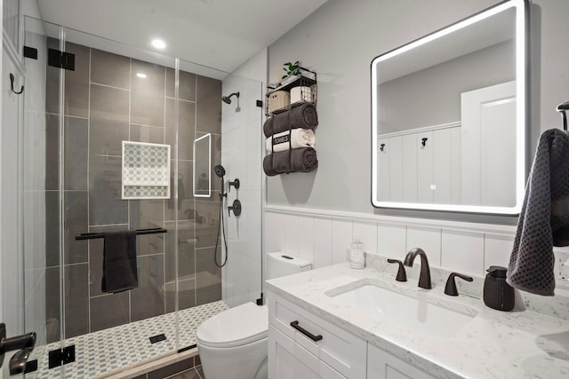 bathroom with vanity, wainscoting, toilet, recessed lighting, and a stall shower