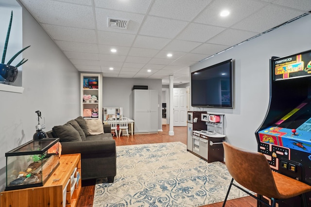 living room featuring recessed lighting, visible vents, a drop ceiling, and wood finished floors