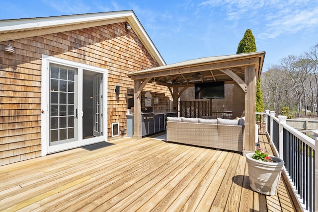 wooden terrace with an outdoor kitchen, a gazebo, french doors, and an outdoor hangout area
